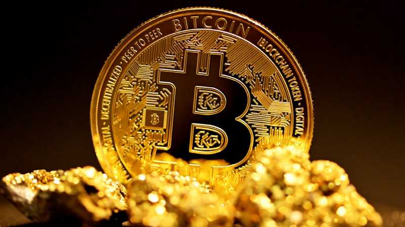 a bitcoin sitting on top of a pile of gold nuggets - A single bitcoin surrounded by raw gold pieces., tags: high - unsplash